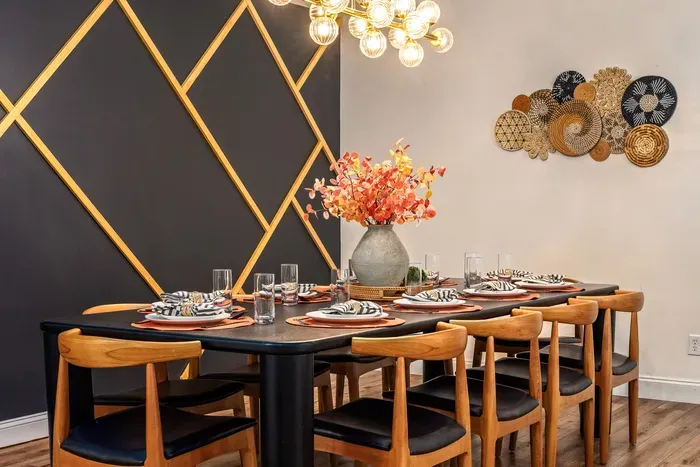 Stylish dining room for 8 with designer lighting and bold accent wall