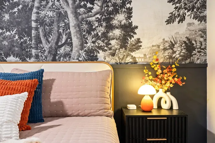 Boutique-style bedroom with mural wallpaper and warm designer touches
