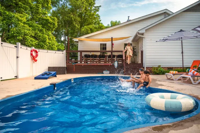 Private backyard pool with lounge seating and shaded deck retreat