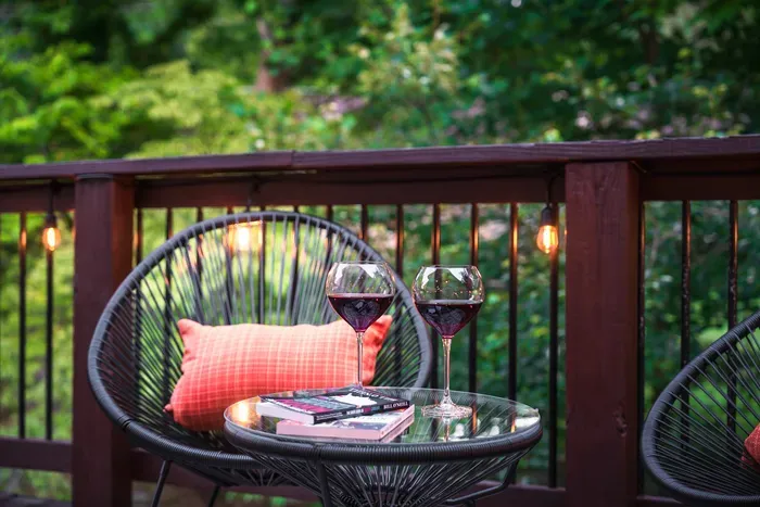 Cozy wooded deck with wine, string lights, and inviting seating