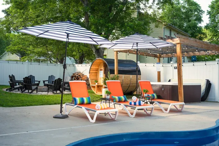 Private resort-style backyard with hot tub, sauna, fire pit & pool loungers