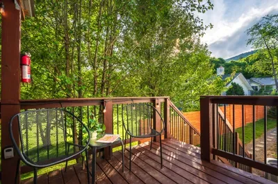 Private tree-lined deck with cozy seating and peaceful outdoor views