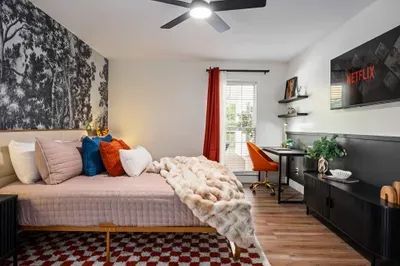 Stylish bedroom with workspace, TV, and cozy boutique-style decor