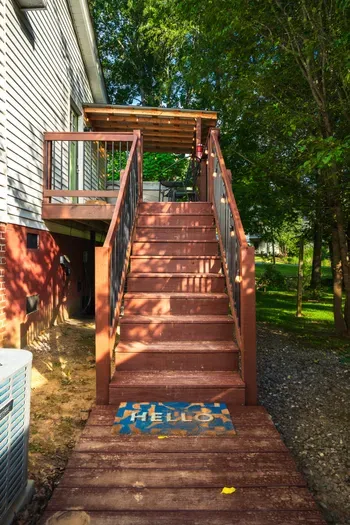 Private covered deck entrance surrounded by mature trees