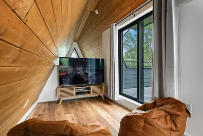A cozy upstairs retreat with bean bag seating, PS4 console, and a large-screen TV. Slide open the doors to your private sundeck for fresh air and stunning lake views.
