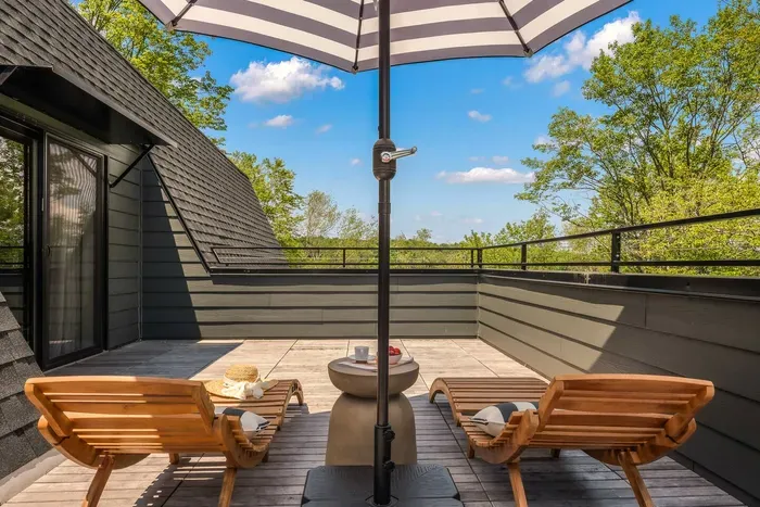 Private upper balcony with lounge chairs and umbrella — the perfect spot to sip coffee, sunbathe, or enjoy tree-top views in total relaxation.