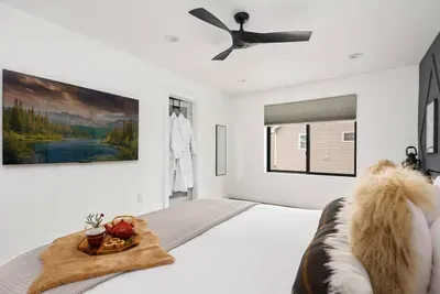 Spacious upstairs primary king suite featuring a large walk-in closet, blackout shades, and ceiling fan. Enjoy a cozy movie night with the in-room smart TV and relax with plush robes for a true luxury retreat.