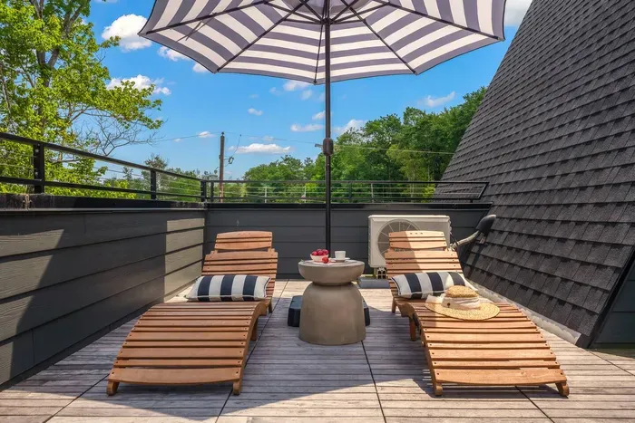 Soak up the sun on the upper balcony, complete with loungers, umbrella shade, and treetop views — your private outdoor retreat.