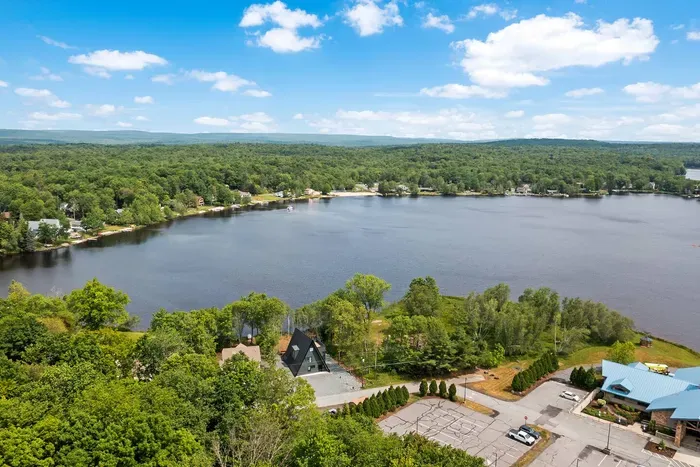 Stunning aerial photo captures Moonlit Peak’s incredible lakefront location, with sweeping views of serene waters and surrounding natural beauty. Highlighted also is the close proximity of The Lodge, a hub of premium amenities and activities.