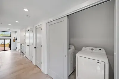 This first floor laundry area offers the ultimate convenience for guests.  Equipped with a washer and dryer tucked neatly behind sliding doors, it's perfect for extended stays or quick clean-ups after a day of exploring.