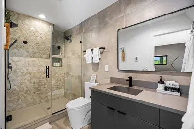 Primary en-suite with dual shower heads, heated floors, and a sleek modern design for a spa-like experience.