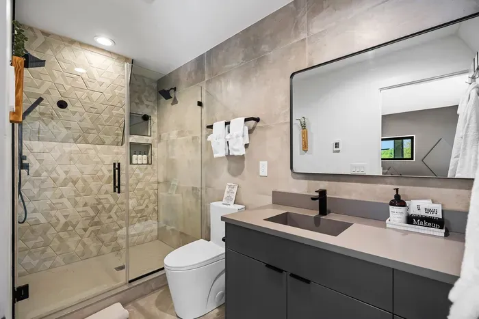 Primary en-suite with dual shower heads, heated floors, and a sleek modern design for a spa-like experience.