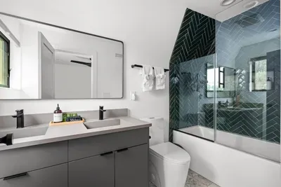 Modern ensuite full bathroom with a sleek vanity, tub and shower combo, and heated floors for extra comfort.