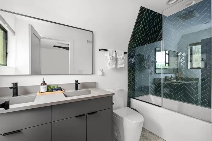 Modern ensuite full bathroom with a sleek vanity, tub and shower combo, and heated floors for extra comfort.