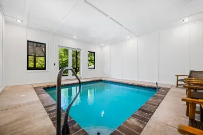Indoor pool with a full wall of windows facing the woods. Cannonballs at midnight, laps at sunrise, weather never a factor.