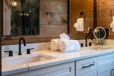 Double vanity with quartz counters and matte black fixtures. No morning traffic jam, even with a group this size.