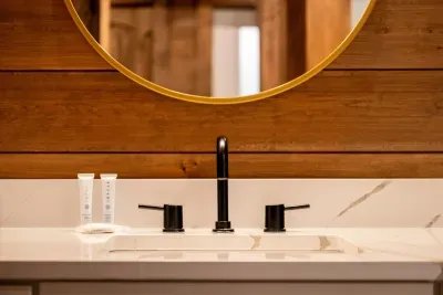 Gold-rimmed mirror, matte black tap, toiletries stocked. All the small things handled before you walk in.