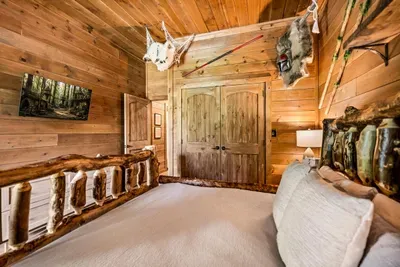 Log-frame bed and vintage mountain details throughout. A room that leans full lodge, in the best way.