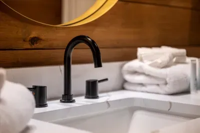Rolled towels, deep basin, rainfall-shower finish. Everything restocked and ready before you arrive.