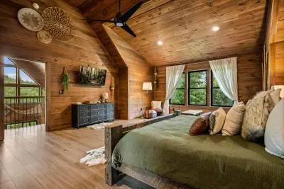 Room to genuinely spread out: king bed, seating, full dresser, and a window filled with green.