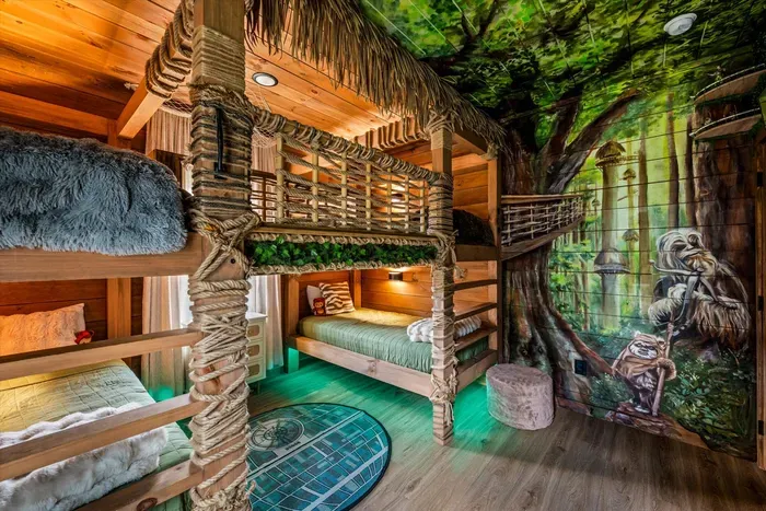 A tree grows straight through this bunk room, mural walls and all. Adventure-themed sleeping quarters that sell the trip on their own.