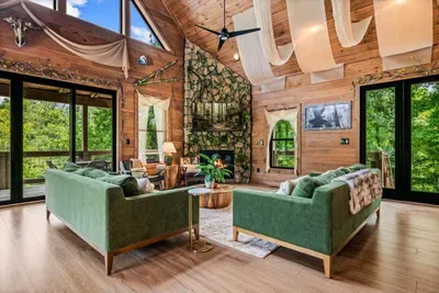 Two full sofas under a vaulted ceiling means nobody's fighting for a spot. Open the doors and the mountain air comes straight in.
