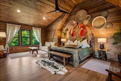 Live-edge headboard, sheepskin underfoot, woven wall art. A suite that reads handcrafted rather than catalog-ordered.