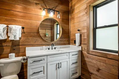 Guest bath with a quartz vanity, private window, and towels waiting where you'd want them.