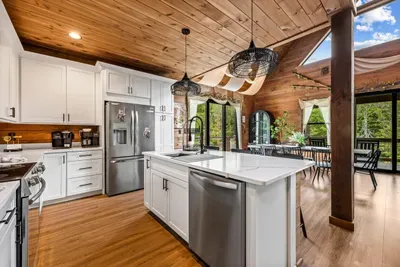 Quartz island, open sightlines, and pine beams overhead. Whoever's cooking never gets stuck alone in here.