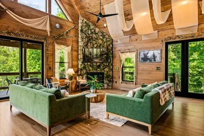 The fireplace anchors the room and the windows do the rest. Board games, movie nights, or nothing at all — the group keeps drifting back here.