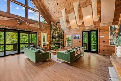 Sliding doors open the living room straight onto the deck, so the evening flows in and out. Vaulted pine, forest views, and room for the whole crew.