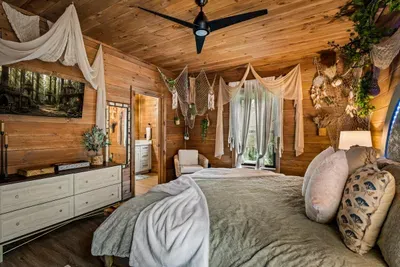 Suite with its own bath, smart TV, and enough dresser space for a real week away. Forest right outside the glass.