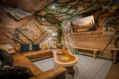 A woodland-themed lounge with leather seating, hand-built branch detailing, and a canopy overhead. Official rainy-day headquarters.