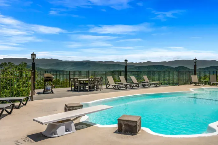 Diving board, a real deep end, and a mountain range behind it