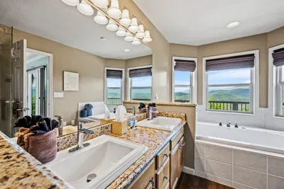 Two sinks, a jetted tub, and windows on two walls