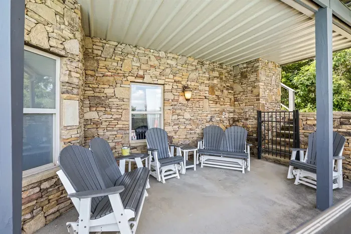Covered stone porch with rockers, works rain or shine