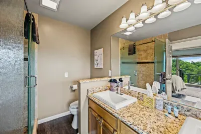 Glass walk-in shower, granite vanity, natural light