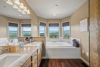 Double vanity and a jetted corner tub wrapped in windows
