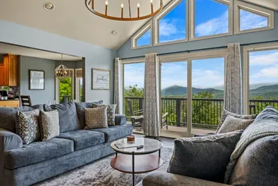 Wall-to-wall windows, vaulted ceiling, sofas facing the ridge