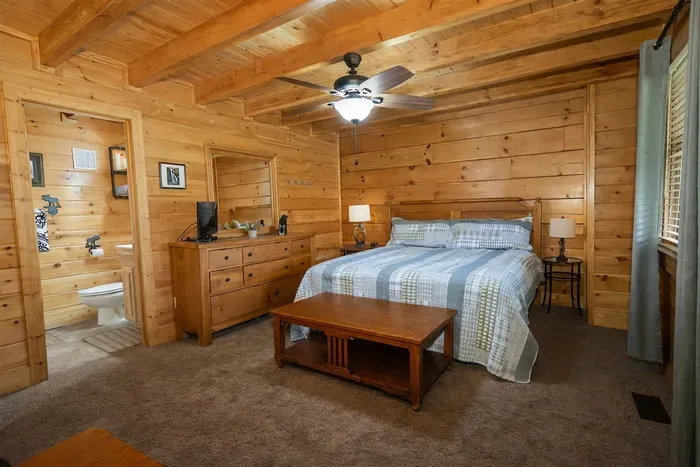 Your cozy cabin retreat awaits—comfort, privacy, and a gentle breeze from the ceiling fan.