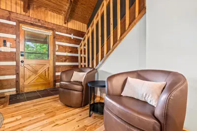 Leather swivel chairs tuck beside a barn-door entry and warm log walls — the easy landing spot where you kick off your boots and let the cabin take over. Settle in the moment you arrive.