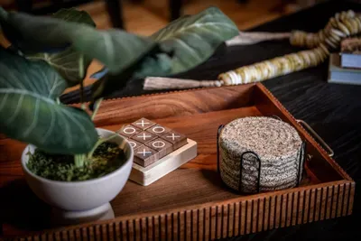 Handcrafted details at every turn — a wooden tic-tac-toe set, artisan coasters, and fresh botanicals styled for the guests who notice the little things.