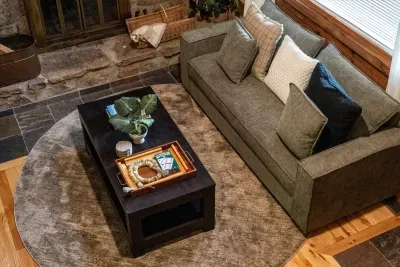 A wraparound sectional piled with pillows circles the coffee table — built for board games, long talks, and the slow unwind after dark. The room the group keeps coming back to.