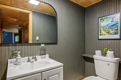 A crisp board-and-batten bathroom keeps the cabin feeling effortless — full vanity, ample counter space, and a calm gray palette that makes slow mountain mornings easy. Everything where you'd want it.