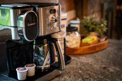 Your mornings start right — Cuisinart coffee maker, K-Cup ready, with mountain air drifting through the windows. First cup never hit different.