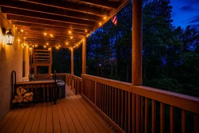 String lights glow over a wraparound porch that melts into the treetops — coffee at sunrise, a glass of wine at dusk, green as far as you can see. Can you picture slowing down here?