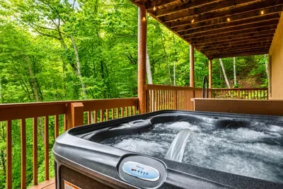 A private hot tub waits on the covered deck, tucked into the canopy and ready whenever you are. Peel back the cover, ease in, and let the mountain air do the rest.