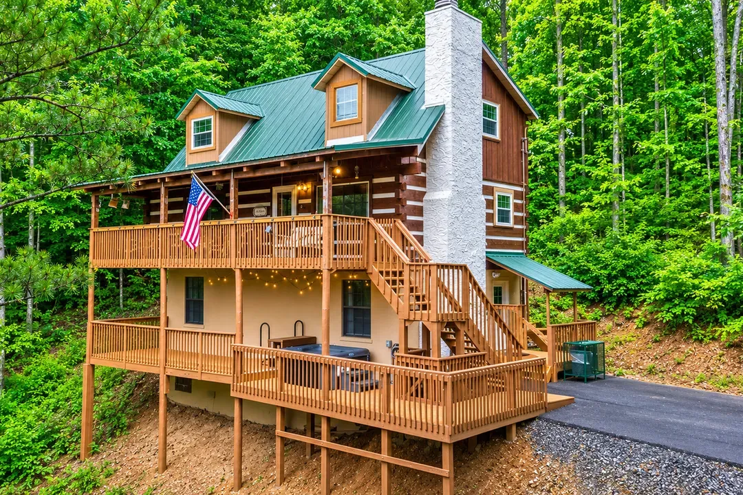 A handcrafted log cabin rising three levels into the canopy — stacked decks, a stone chimney, and porches made for long evenings. Room to spread out and a view that never quits.