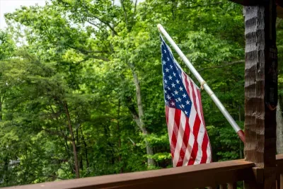 Step onto the deck and the forest wraps right around you — flag flying, leaves whispering, nothing on the agenda. Breathe in; this is exactly the quiet you came for.