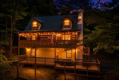 Real log construction, wraparound decks on every floor, forest pressing in on all sides — this is the mountain cabin guests picture when they dream up the trip. Yours for the week.